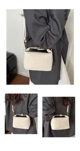 Detail view of beige crossbody tote bag with subtle leopard print and gold hardware