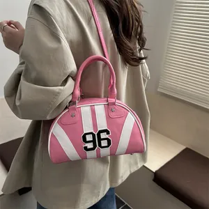Borsa bowling rosa con toppa numero 96 e borchie a stella indossata da una modella