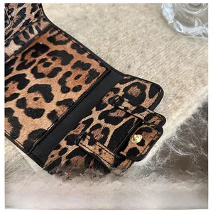 Détail du mini sac léopard montrant les coutures de qualité et le fermoir doré chic