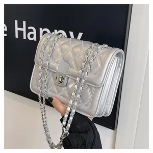 Detailansicht der silbernen Stepptasche mit Kettenriemen, Drehverschluss und Faltendesign