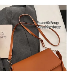 Détail du sac bandoulière en cuir caramel avec bandoulière lisse et boucle dorée