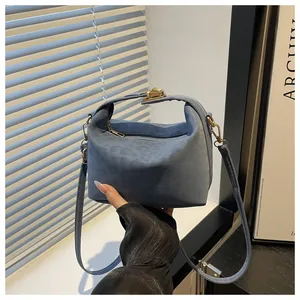Blue suede tote bag with metal buckle shown in a lifestyle setting for commute