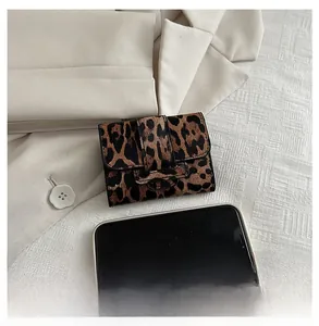 Mini sac carré à motif léopard à côté d'un smartphone pour comparer la taille