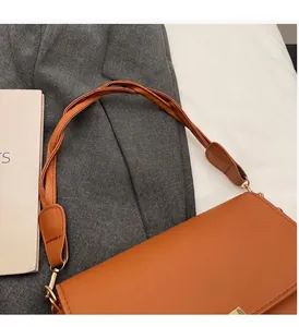 Détail du sac à main marron vintage avec poignée nouée et fermoir en métal doré élégant