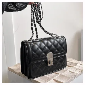Detail einer schwarzen Stepptasche aus Leder mit Silberkette und Drehverschluss