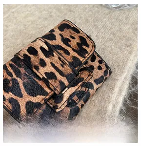 Détail d'un mini sac léopard avec boucle sur fond en maille douce pour un style chic