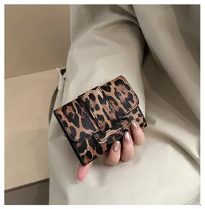 Gros plan d'un mini portefeuille léopard avec cuir texturé et fermoir élégant