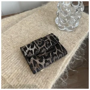 Détail d'un portefeuille pliable motif léopard en similicuir de qualité avec fermeture à bride