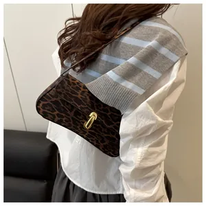 Close-up of a leopard print shoulder bag with a vintage gold metal oval buckle and strap