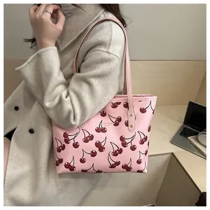 Sac fourre-tout rose avec imprimé cerises et texte doré dans un décor urbain chic