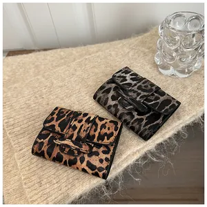 Gros plan de mini portefeuilles à imprimé léopard sur fond en maille douce avec texture