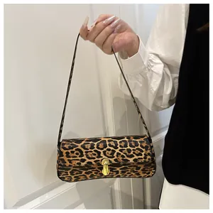 Close-up of leopard print shoulder bag featuring a premium gold metallic twist lock