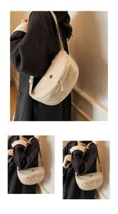 Detalle del bolso bandolera beige de nailon con doble cremallera y logotipo circular