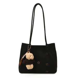 Vintage black suede tote bag with hollow floral pattern and a cute plush bear charm
