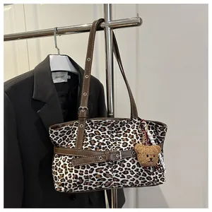 Detail der Leoparden-Wildleder-Tasche mit braunen Lederriemen und Plüschbär-Anhänger