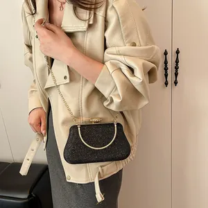 Elegante borsa da sera nera glitterata con catena dorata e manico indossata da una modella