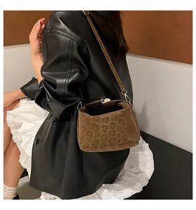 Detail of leopard print faux fur doctor bag featuring vintage metal clasp and leather strap