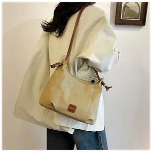 Détail du sac bandoulière minimaliste avec lanières marron et étiquette mode élégante