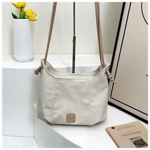 Détail du sac ivoire avec étiquette en cuir Fashion et nœuds de serrage sur le côté