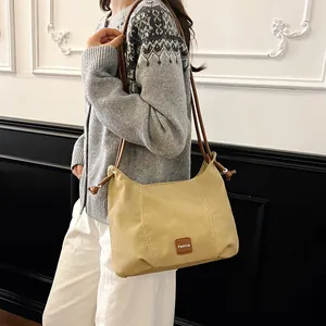 Sac à bandoulière beige minimaliste pour femme avec garniture en cuir brun et nœud déco