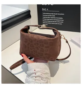Detail of leopard print suede handbag featuring golden buckle and versatile strap