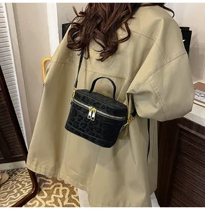 Detail der schwarzen Box-Tasche mit Leopardenmuster, Goldteilen und abnehmbarem Gurt