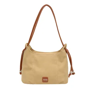 Sac bandoulière beige minimaliste avec bretelles marron et détails de cordon