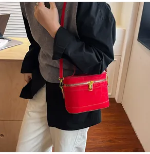 Detail der roten minimalistischen Box-Tasche mit zwei Gold-Reißverschlüssen und Ledertextur