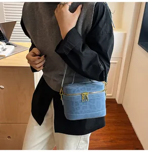 Detailansicht der blauen Tasche mit Leopardenmuster, goldenem Reißverschluss und Trageriemen