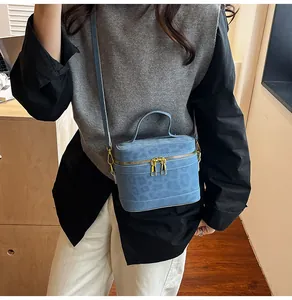 Detailansicht der blauen Box-Tasche mit Leopardenmuster, Goldreißverschluss und Gurt