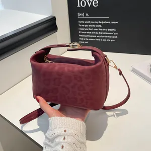 Elegant burgundy underarm bag with leopard texture and golden metallic clasp detail