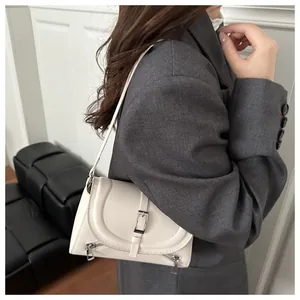Détail du sac à bandoulière en cuir crème avec zips argentés et boucle métallique