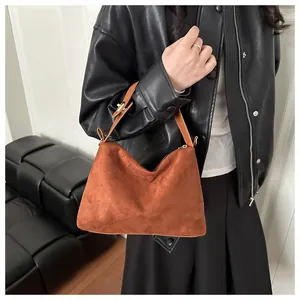 Detailed texture of the vintage brown suede shoulder bag with smooth zipper closure
