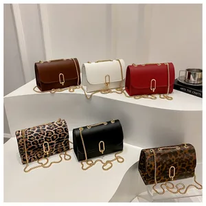 Dettagli di mini borse a catena eleganti in tinta unita e stampe leopardate con fibbie d'oro