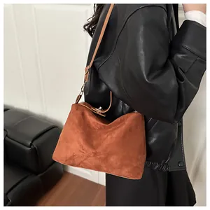Close-up of vintage brown suede crossbody bag with elegant metal twist lock detail