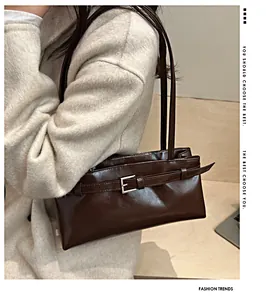 Détail du sac porté épaule en cuir marron foncé avec boucle de ceinture décorative