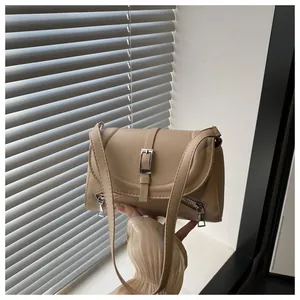 Détail du sac bandoulière en cuir PU kaki avec boucle argentée et détails de zip latéraux
