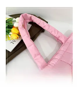 Close-up of pink quilted tote bag showing soft square stitching and padded handle