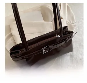 Détail du sac à bandoulière en cuir ciré marron foncé avec fermeture éclair et boucle