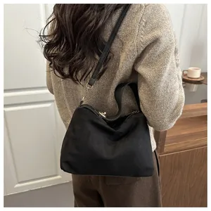 Detail of vintage black suede tote bag with golden metal twist lock and shoulder strap