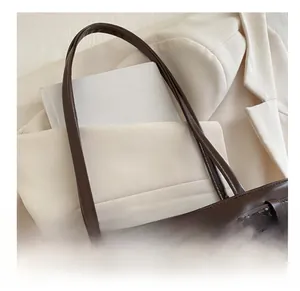 Vue détaillée de la bandoulière en cuir ciré marron foncé et de la boucle sur le sac