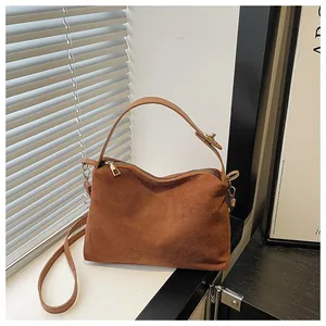 Detail of vintage brown suede tote with gold zipper and adjustable leather strap