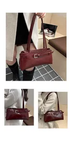 Détail du sac à bandoulière en cuir bordeaux avec ceinture décorative et boucle carrée argentée