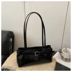 Gros plan d'un sac bandoulière en cuir ciré noir brillant avec boucle argentée élégante