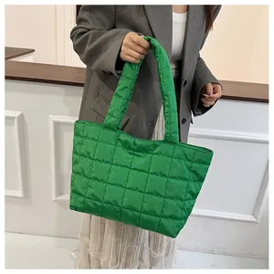 Close-up of vibrant green quilted puffy tote bag made of nylon fabric with square patterns