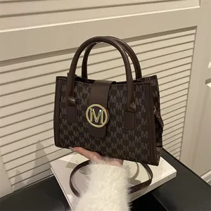 Bolso tote marrón vintage con patrón de monograma y hebilla dorada con el logo M