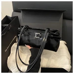 Détail du sac à bandoulière noir brillant avec fermoir argenté sur doublure en soie