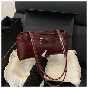 Sac à main bordeaux en cuir huilé présenté dans un coffret cadeau avec emballage noir