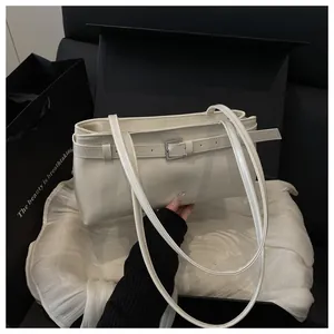Détail du sac sous le bras blanc crème avec boucle décorative et doubles bretelles