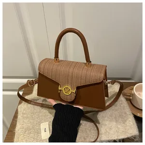 Dettaglio borsa a tracolla marrone vintage con trama intrecciata e chiusura dorata M